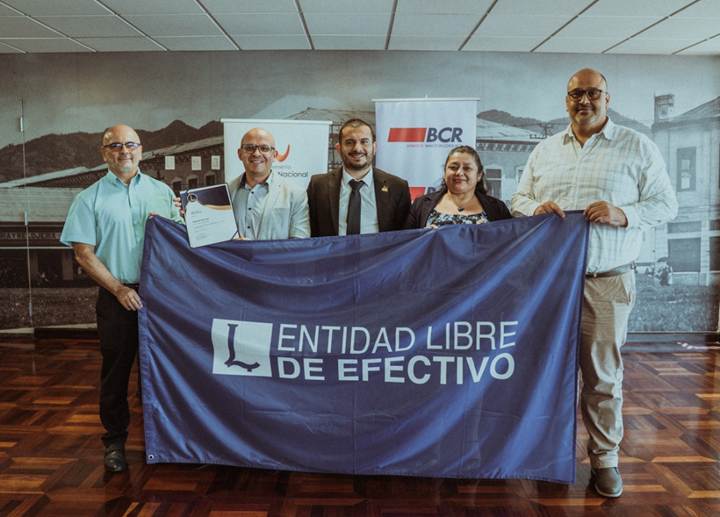 Director general de la Imprenta Nacional y funcionarios de esta instituci&oacute;n posan con la bandera de entidad libre de efectivo.